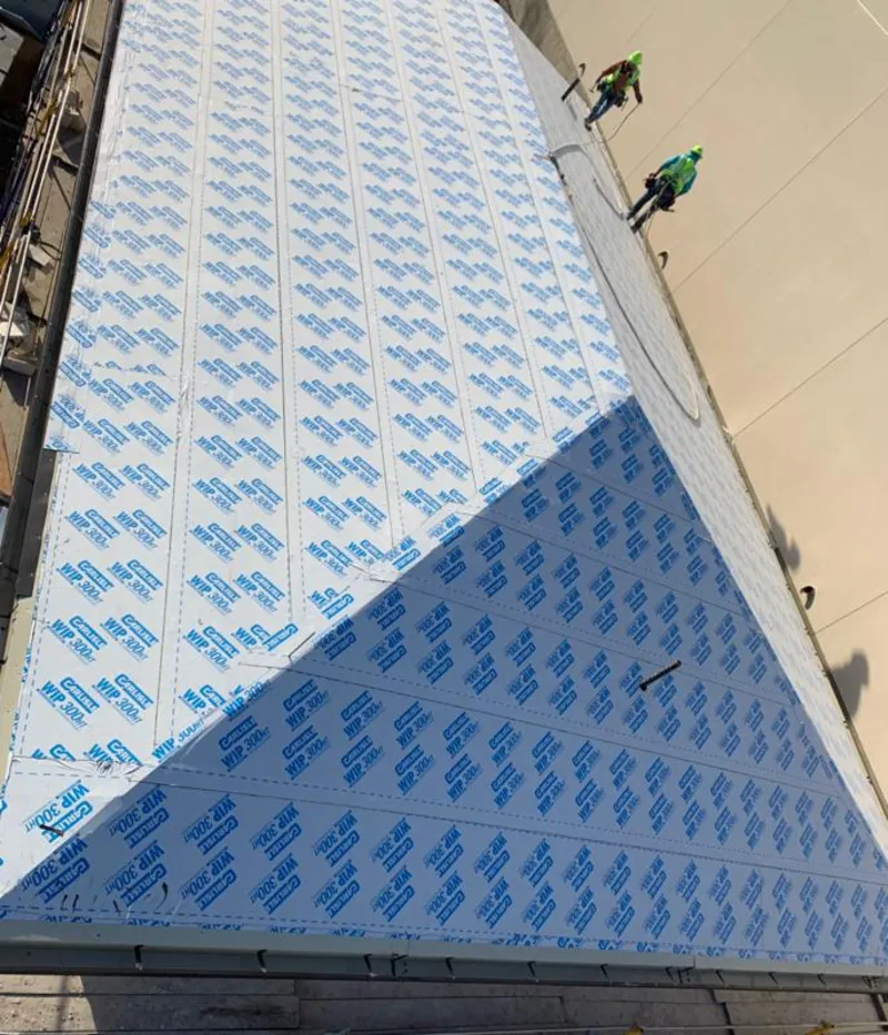 Professional roofers installing underlayment on a metal roof in Orange